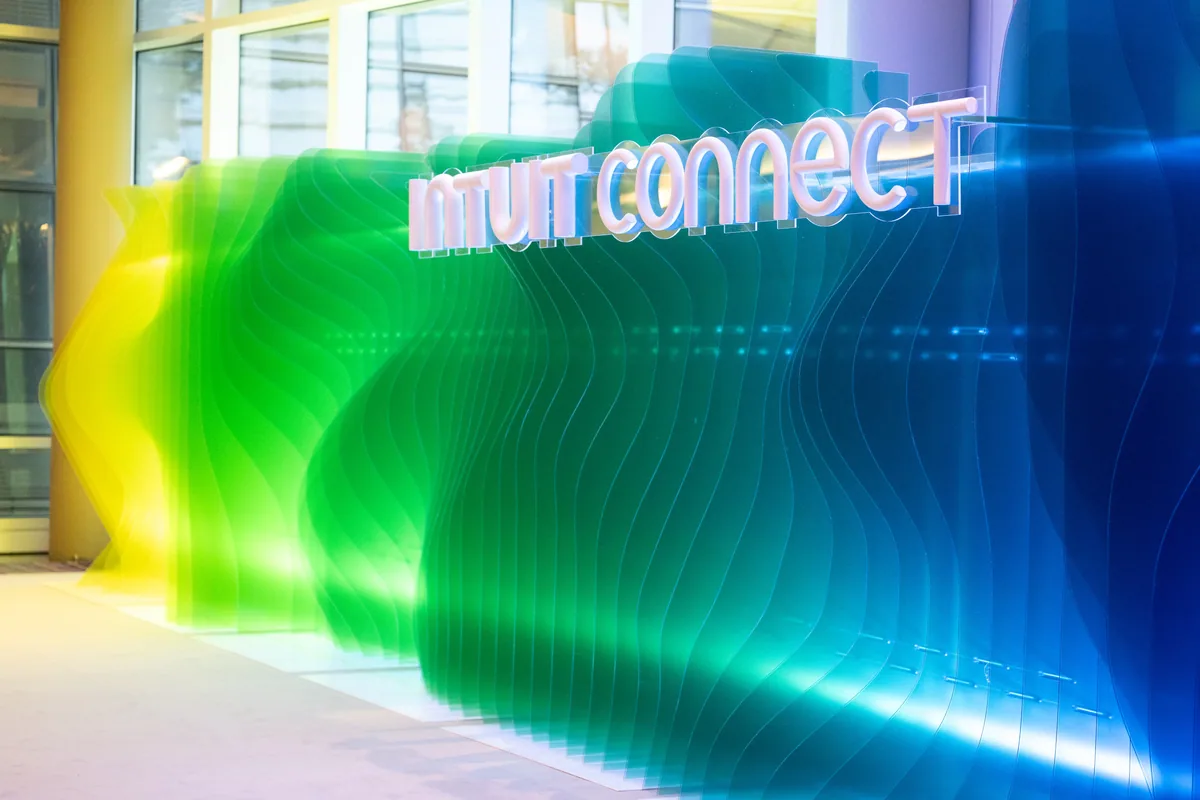 Layered acrylic wave wall in green and blue gradients with Intuit Connect lettering
