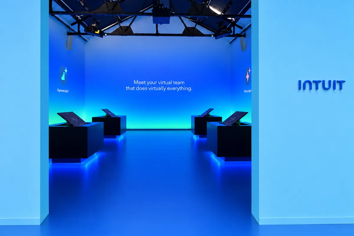Gallery entry beside an Intuit logo, opening onto a blue demo room that reads Meet your virtual team