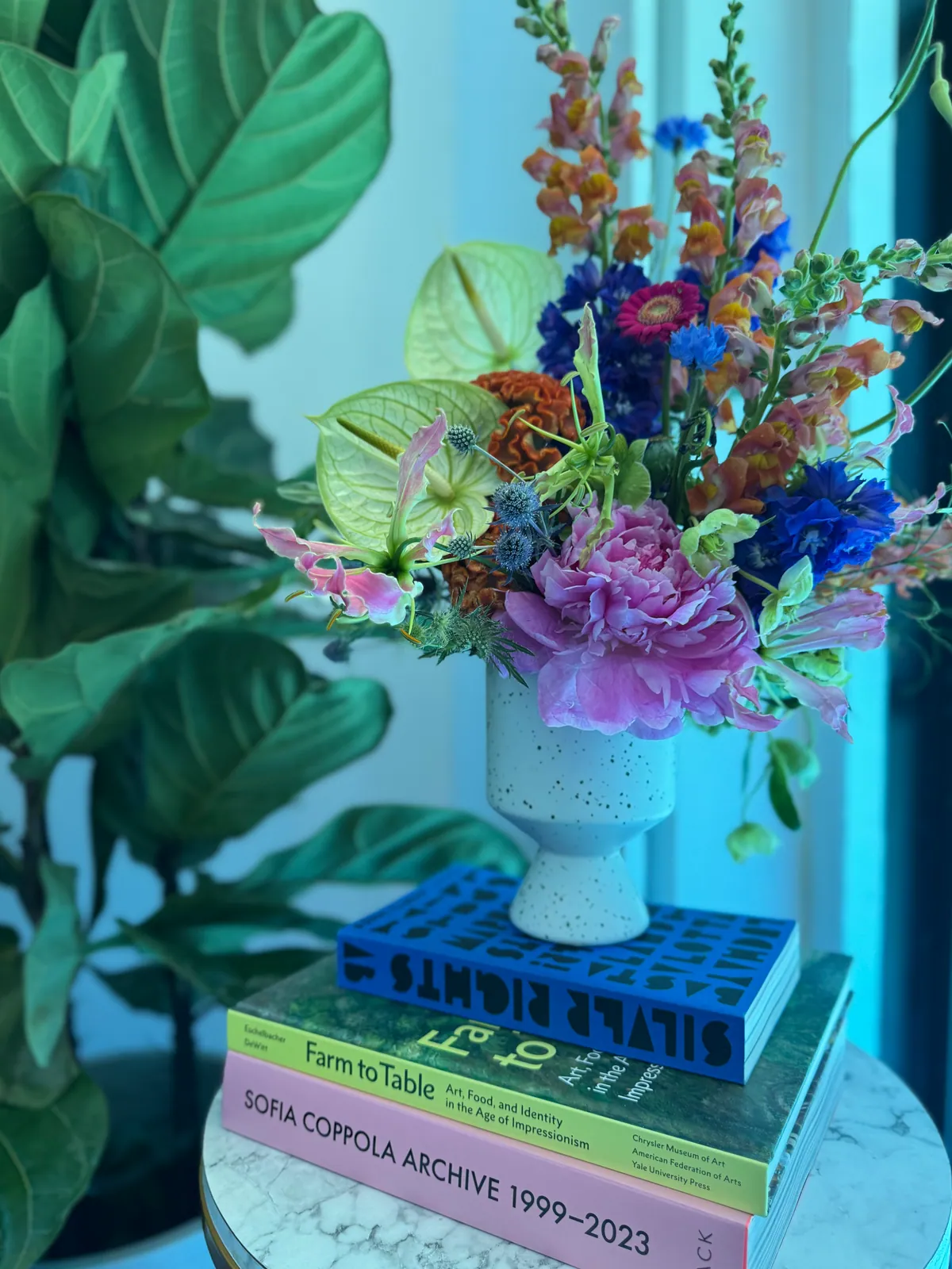 Floral arrangement on a stack of design books