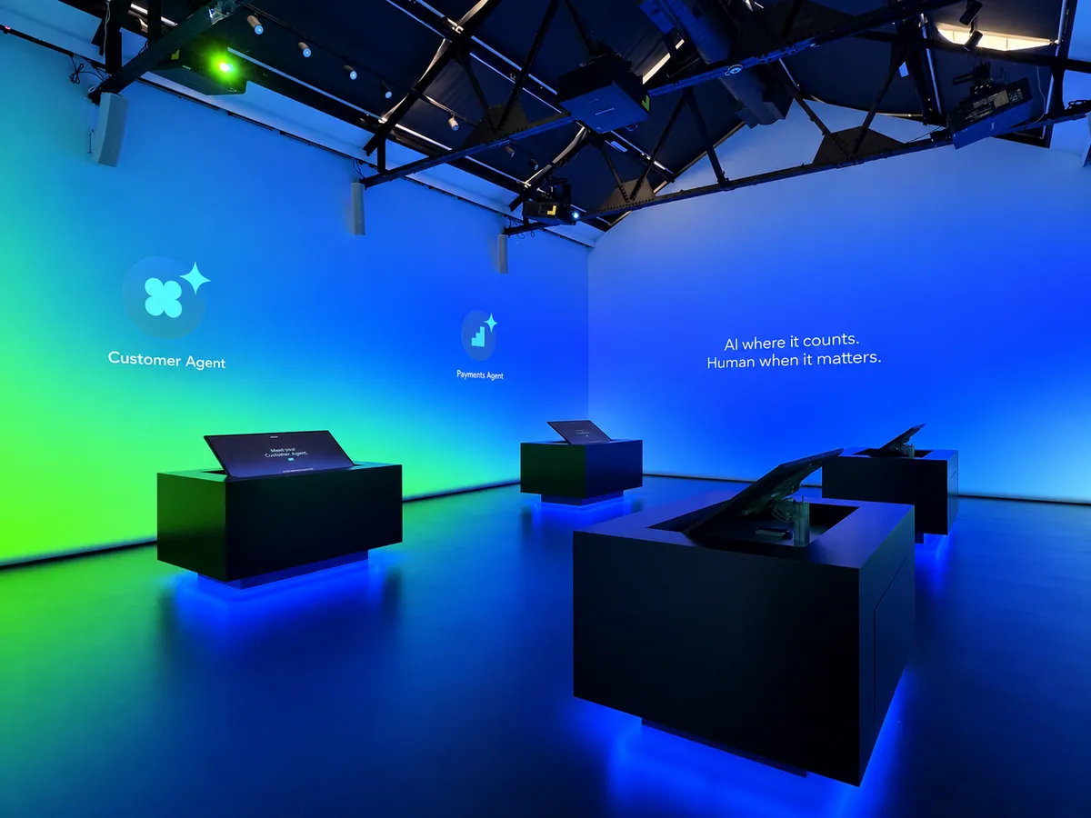 Demo room with four black demo stations under blue and green projection