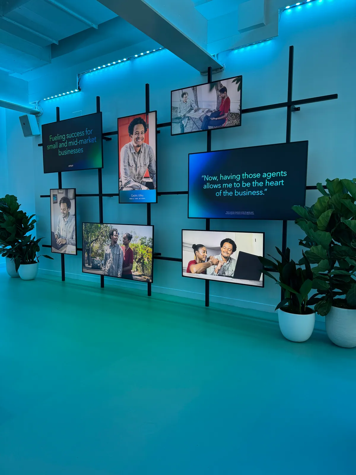 Video wall of customer stories on a black grid
