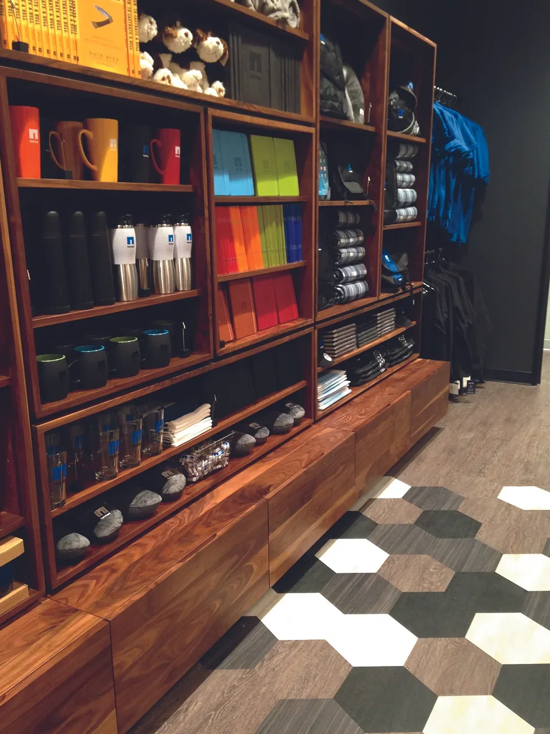 Hexagon tiles set into the wood plank floor in front of stocked shelves
